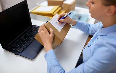 Image showing close up of woman filling postal form at office