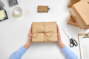 Image showing hands with parcel box tied by rope at post office