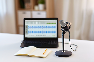 Image showing microphone, laptop and notebook on table