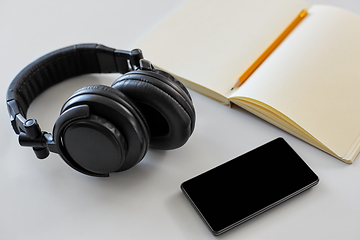 Image showing headphones, smartphone and notebook with pencil