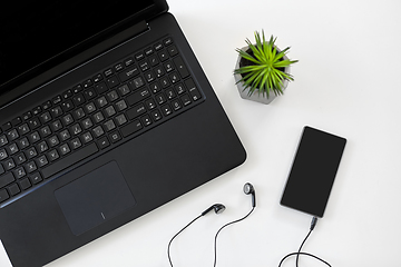 Image showing close up of laptop, smartphone and earphones