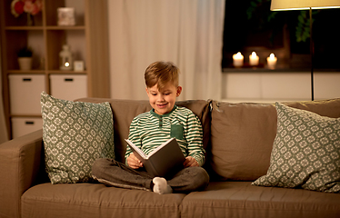 Image showing happy little boy reading book at home
