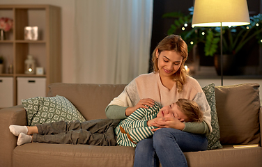 Image showing happy mother with sleeping little son at home