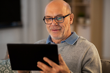 Image showing happy senior man with tablet computer at home