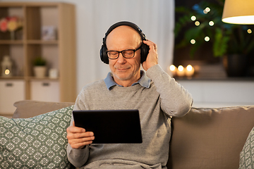 Image showing senior man with tablet pc and headphones at home