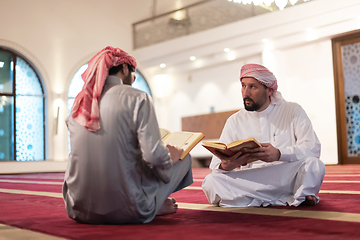 Image showing two muslim people in mosque reading quran together concept of islamic education