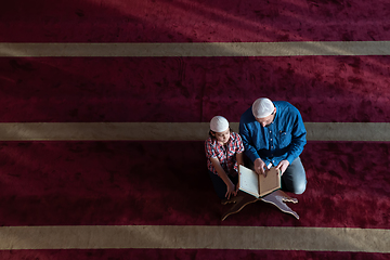 Image showing father and son reading holly book quran together islamic education concept