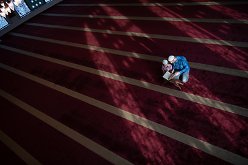 Image showing father and son reading holly book quran together islamic education concept