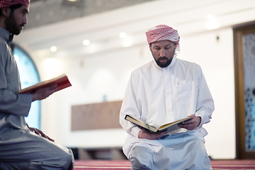 Image showing two muslim people in mosque reading quran together concept of islamic education