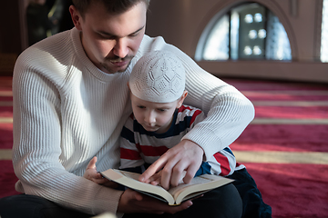 Image showing  father and son in mosque praying and reading holly book quran together islamic education concept