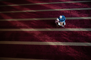 Image showing father and son reading holly book quran together islamic education concept