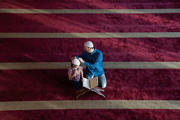 Image showing father and son reading holly book quran together islamic education concept