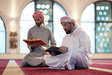 Image showing two muslim people in mosque reading quran together concept of islamic education