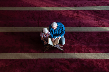 Image showing father and son reading holly book quran together islamic education concept