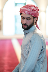 Image showing a Muslim ends a prayer by turning his head to the side,.