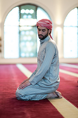 Image showing a Muslim ends a prayer by turning his head to the side,.