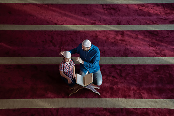 Image showing father and son reading holly book quran together islamic education concept