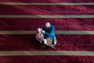 Image showing father and son reading holly book quran together islamic education concept