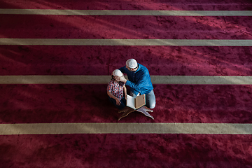 Image showing father and son reading holly book quran together islamic education concept