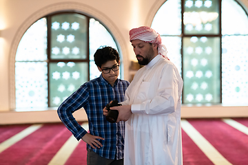 Image showing the father explains to his son how to use the camera in mosque