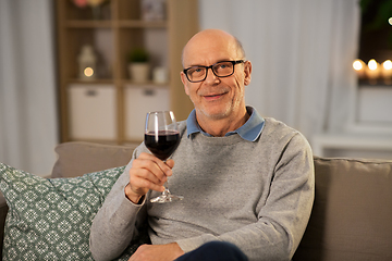 Image showing senior man drinking red wine from glass at home