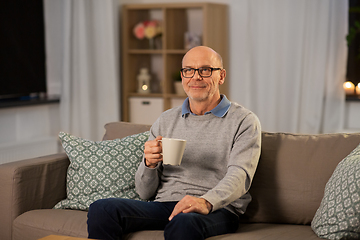 Image showing happy senior man with cup of tea at home