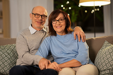 Image showing happy senior couple hugging on sofa at home