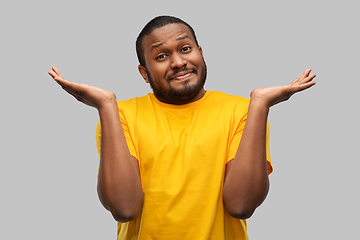 Image showing african american man in yellow t-shirt shrugging