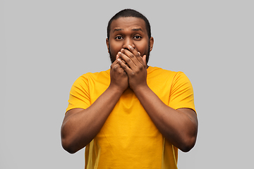 Image showing scared african american man covering his mouth