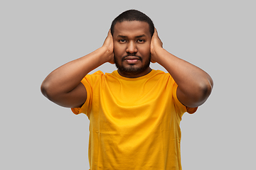 Image showing stressed man closing his ears with hands