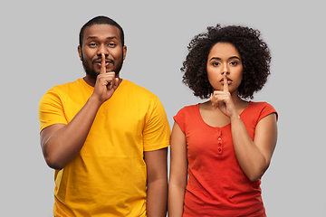 Image showing happy african american couple making hush gesture