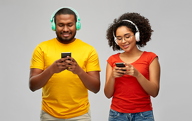 Image showing african couple with headphones and smartphones
