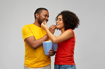 Image showing happy african american couple eating popcorn