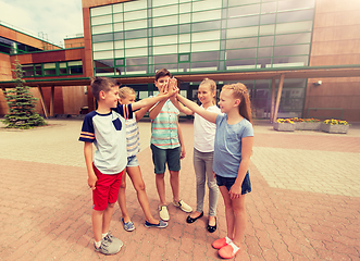 Image showing group of children making high five at school yard