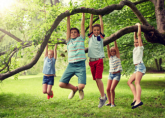 Image showing happy kids hanging on tree in summer park