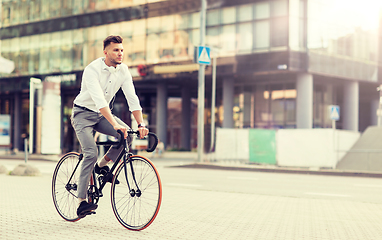 Image showing man with headphones riding bicycle on city street