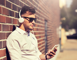 Image showing man with headphones and smartphone listening music