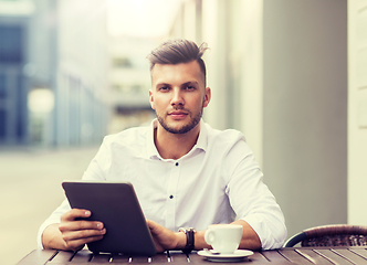 Image showing man with tablet pc and coffee at city cafe