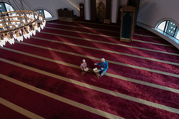 Image showing father and son reading holly book quran together islamic education concept