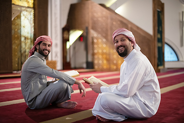 Image showing two muslim people in mosque reading quran together concept of islamic education