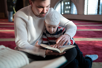 Image showing  father and son in mosque praying and reading holly book quran together islamic education concept