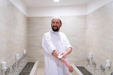 Image showing a portrait of a man in abdesthana using a towel