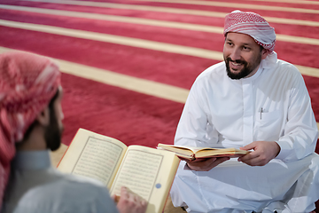 Image showing two muslim people in mosque reading quran together concept of islamic education