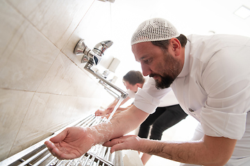 Image showing a group of Muslims take ablution for prayer. Islamic religious rite