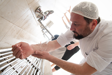 Image showing a group of Muslims take ablution for prayer. Islamic religious rite