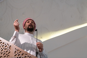 Image showing Muslims young arabic Imam has a speech on friday afternoon prayer in mosque.