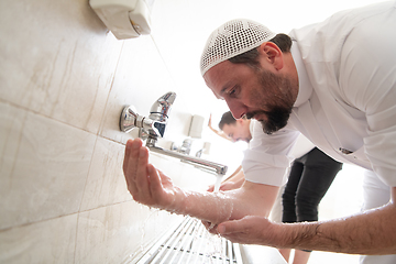 Image showing a group of Muslims take ablution for prayer. Islamic religious rite