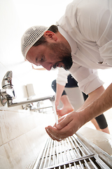 Image showing a group of Muslims take ablution for prayer. Islamic religious rite