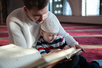 Image showing  father and son in mosque praying and reading holly book quran together islamic education concept