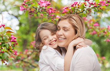 Image showing happy mother and daughter hugging over garden